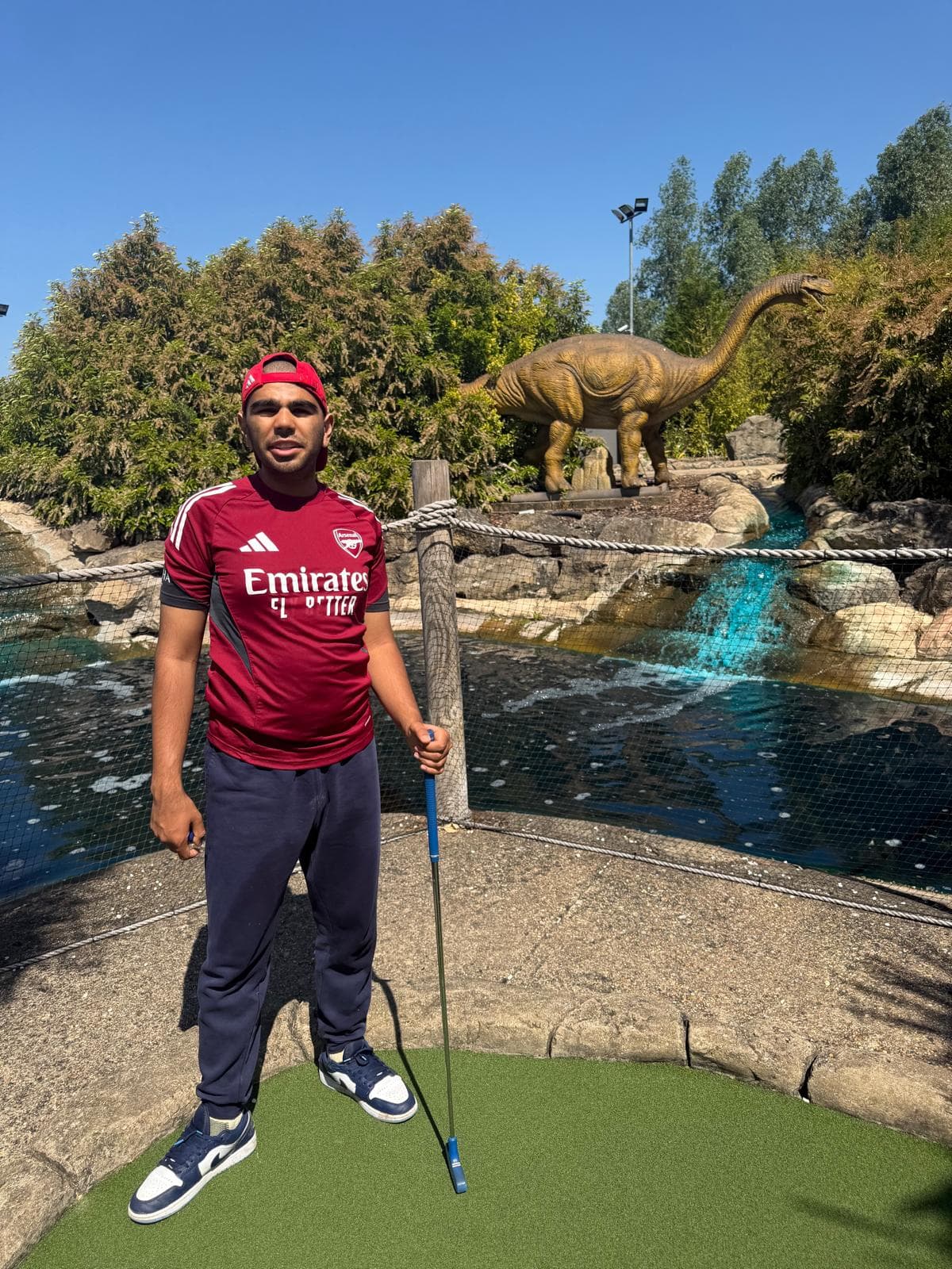 Danyal at crazy golf with a dinosaur